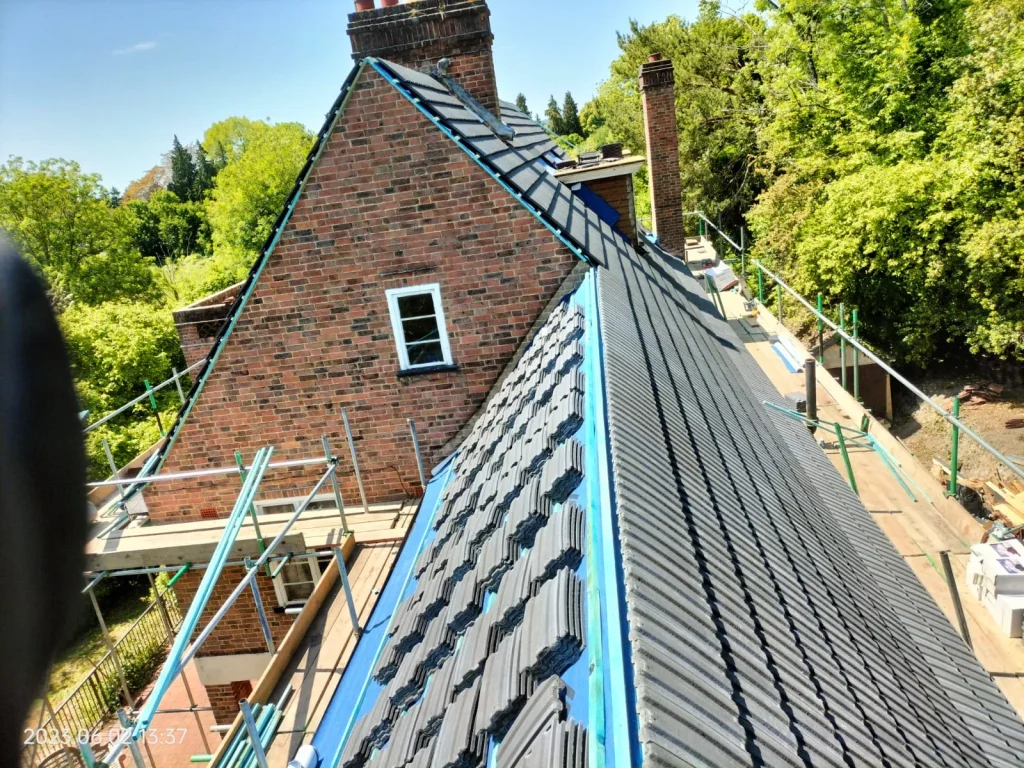 New roof tiles being laid over underlay during a Surrey roof replacement